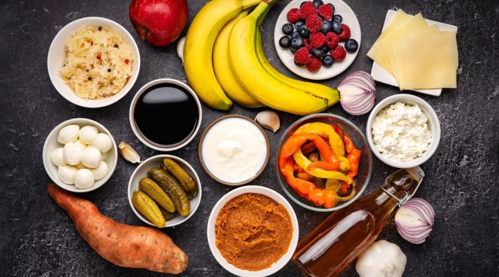 A colorful plate of gut-healthy foods, including yogurt, bananas, and fermented vegetables