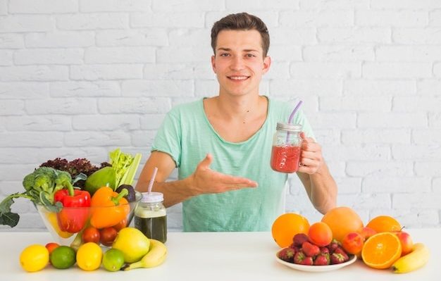 person smiling and holding a healthy smoothie